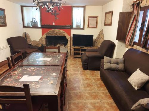 Casa del Águila Dorada في Riópar Viejo: غرفة معيشة مع أريكة وطاولة