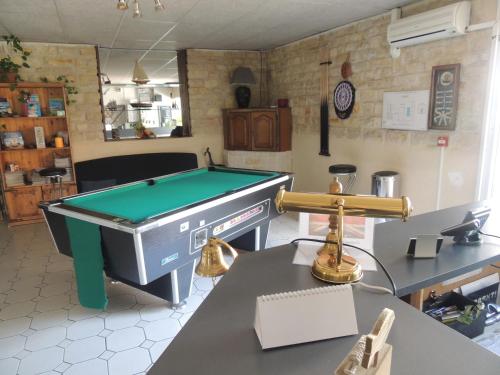 a kitchen with a pool table in a room at Hôtel auberge des charmilles in Sainte-Soulle