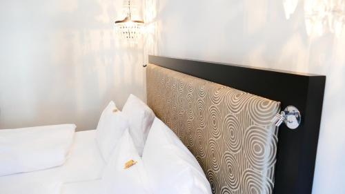 a bed with white sheets and pillows in a room at Hotel an der Oper in Munich
