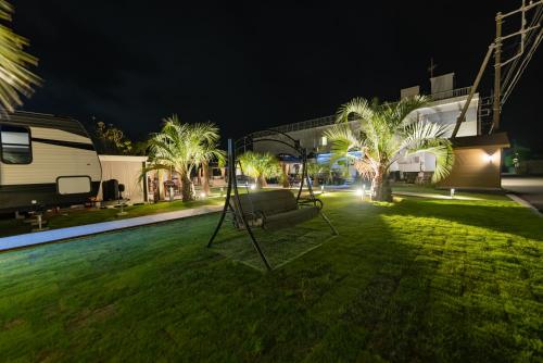 a swing in a yard at night with a rv at Ducale Garden Hotel Kujukuri in Kujukuri