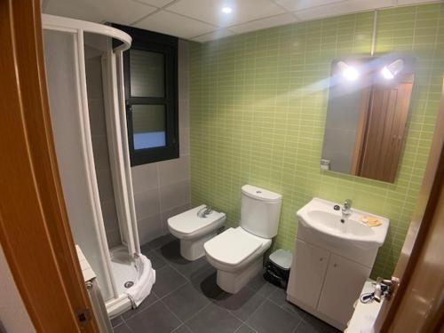 a green tiled bathroom with a toilet and a sink at VUT SEGEDA Valle del Manubles in Calatayud