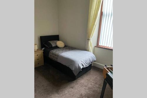a small bedroom with a bed and a window at Preston Villa, spacious ground floor apartment in Buckie