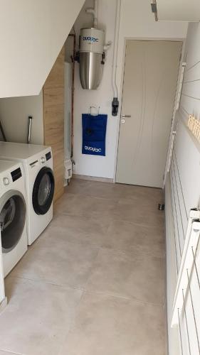 a laundry room with a washing machine and a door at Gîte La Terrasse du Loir à 2km du Zoo de la Flèche in La Flèche