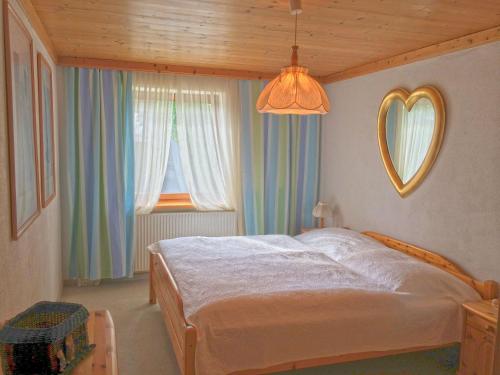 Schlafzimmer mit einem Bett, einem Spiegel und einem Fenster in der Unterkunft Apartment Weinberg in Kirchberg in Tirol