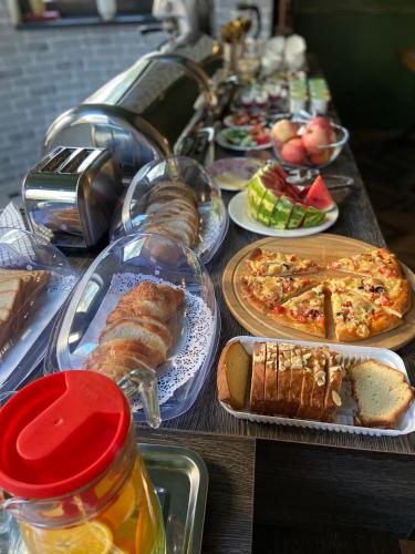a long table with plates of food and bread at SB River Hotels in Atyraū