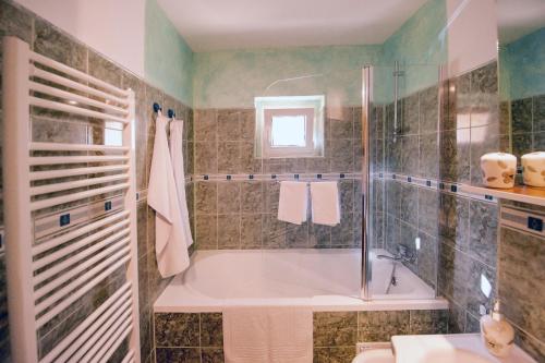 a bathroom with a tub and a shower and a sink at Apartament Beatrice in Râşnov