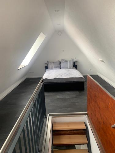 a attic room with a bed and a staircase at Ferienwohnung Wilflingen in Langenenslingen