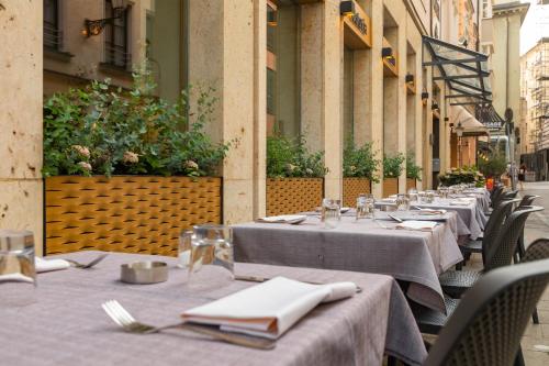 a row of tables with white napkins on a street at Hotel an der Oper in Munich