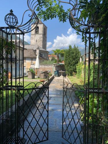 ein offenes Tor zu einem Garten mit einem Turm in der Unterkunft Residence Briona in Domodossola