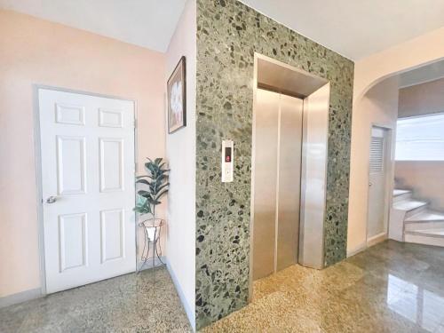 a hallway with a door and a walk in shower at Grand Residence in Bangkok