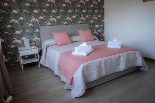 ポンペイにあるLa corte di Emilyのベッドルーム1室(ピンクと白のタオルが付いたベッド1台付)