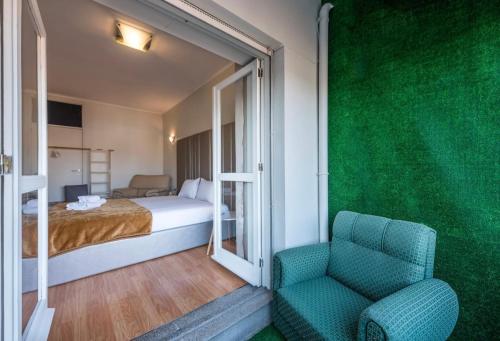 sypialnia z zieloną ścianą, łóżkiem i krzesłem w obiekcie Silver Duque w Porto