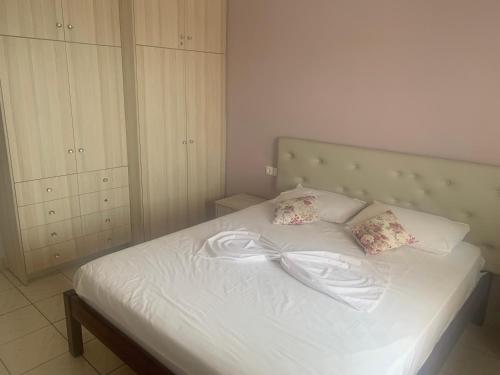 ein weißes Bett mit einer Schleife darauf in der Unterkunft VIEW apartment in Sarandë