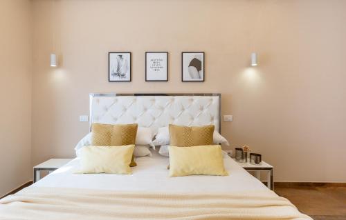 sypialnia z dużym białym łóżkiem z żółtymi poduszkami w obiekcie Club 57 Imperial Rooms w Cagliari