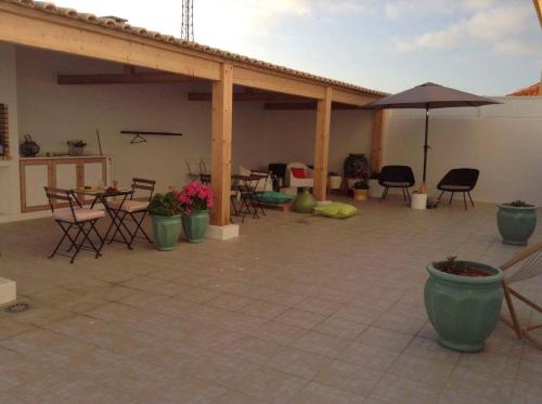 a patio with tables and chairs and an umbrella at White Guest House in Peniche
