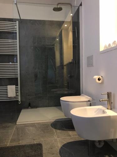 ein Bad mit einer Dusche, einem WC und einem Waschbecken in der Unterkunft Sotto La Vigna Charm Stay Adults only vacation Suite in Montegrosso dʼAsti