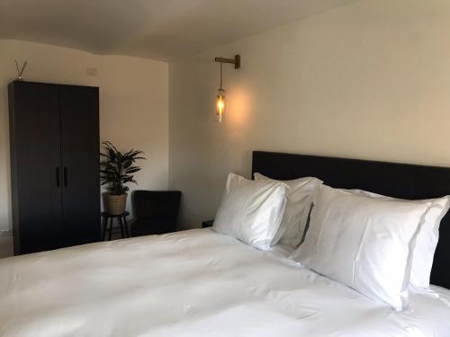 ein Schlafzimmer mit einem weißen Bett mit weißen Kissen in der Unterkunft Sotto La Vigna Charm Stay Adults only vacation Suite in Montegrosso dʼAsti