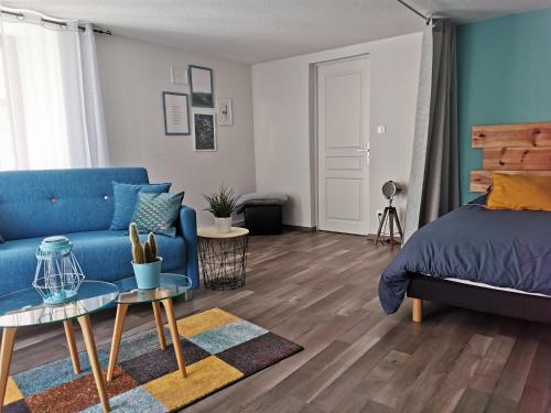 ein Schlafzimmer mit einem blauen Bett und einem blauen Sofa in der Unterkunft Carpe Diem - cote-montagnes in Oderen