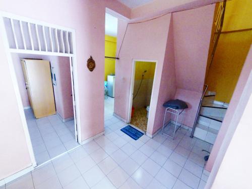 een lege kamer met roze muren en witte tegelvloeren bij Collective Homestay Jogja in Timuran