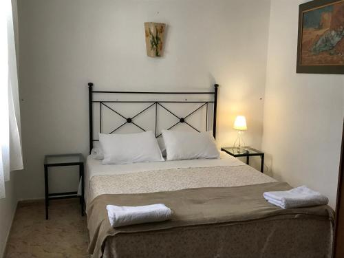 a bedroom with a large bed with two towels on it at Pension el Portillo in Córdoba