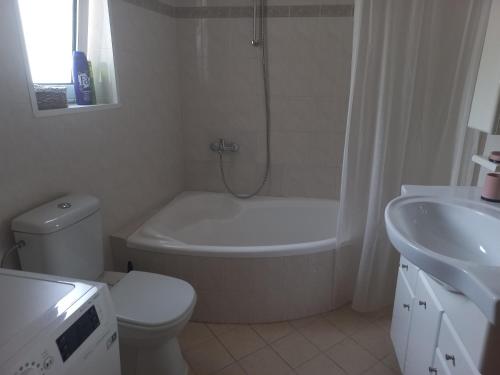 Un baño con bañera, inodoro y lavabo. en Big apartment next to Olympus mountain, en Litóchoron