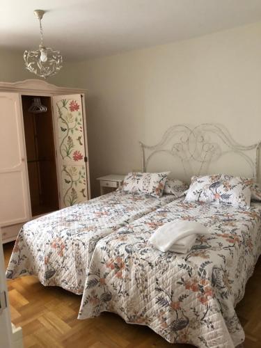 een slaapkamer met een bed met een dekbed erop bij EL JARDÍN DE ALEYDA, VV VACACIONAL in Llanes