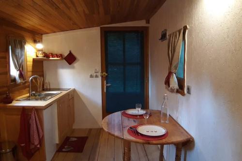 Charmante Roulotte atypique في Jaujac: مطبخ صغير مع طاولة ومغسلة