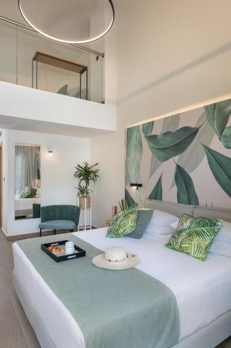 a bedroom with a large white bed with a green patterned wall at Mossa Well Being Hotel - Heated pool in Kato Daratso