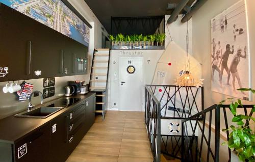 a kitchen with black cabinets and a white refrigerator at Thruster - mini kino, lobby, kuchnia, netflix in Gdynia
