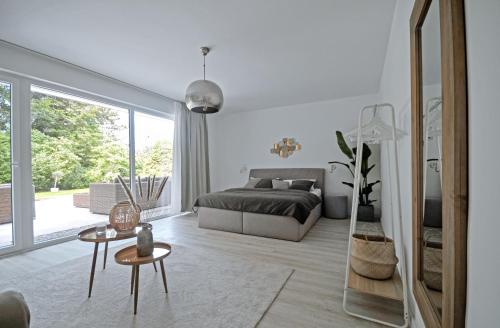 a bedroom with a bed and a large window at Haus Orbis Noster im Harz - Whirlpool und Sauna - direkt am Wald in Bad Grund