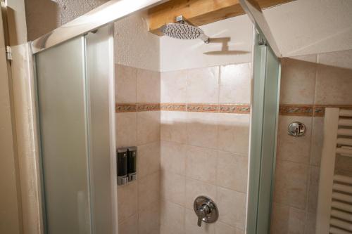 una doccia con porta in vetro in bagno di Pochi passi dalle piste di Les Arnaud a Bardonecchia
