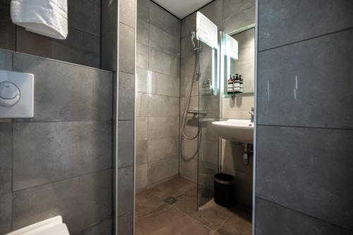 a bathroom with a shower and a sink at HOTELUX Amsterdam Airport Hotel in Hoofddorp