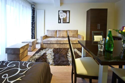 a living room with a couch and a table at Apartamenty Viva Tatry in Zakopane
