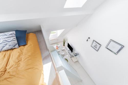 Habitación blanca pequeña con cama y mesa en Le Petit Victor Hugo, en Montfermeil