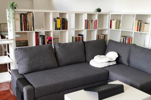 a gray couch in a living room with book shelves at Casa Gaiani Villetta in riva al lago vista mozzafiato in Varano Borghi