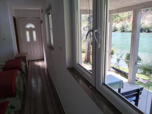 a room with a large window with a view of the water at Apartman na Drini in Foča