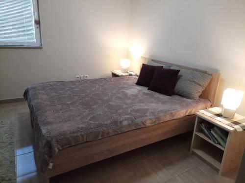 een slaapkamer met een groot bed met 2 nachtkastjes bij Apartman Ristic in Divčibare