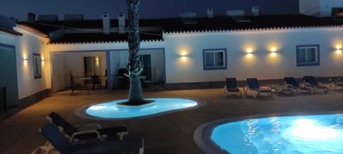 a room with a pool with chairs and a statue at Casa Almeida in Vimieiro