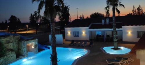 a villa with a swimming pool in front of a house at Casa Almeida in Vimieiro