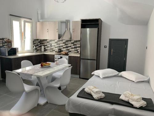 uma cozinha com uma mesa branca e cadeiras num quarto em Thania's House ,4 minutes from the center of Hermoulis em Ermoupoli