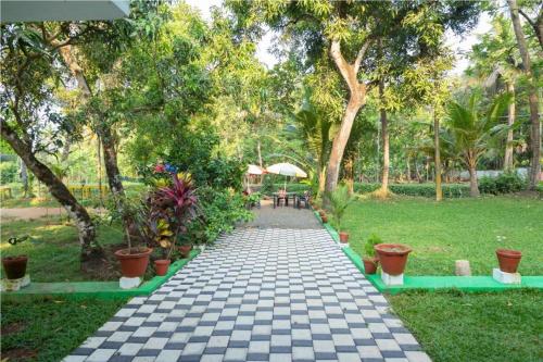 a walkway in a park with plants and trees at Aqualillies Water Front Heritage Homestay in Kumarakom