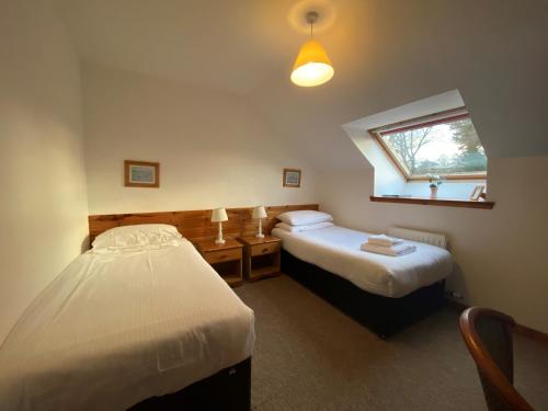 a bedroom with two beds and a window at Smithton Hotel in Inverness