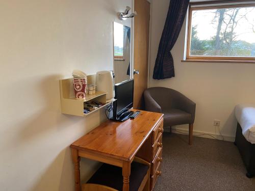 a room with a desk with a computer on it at Smithton Hotel in Inverness
