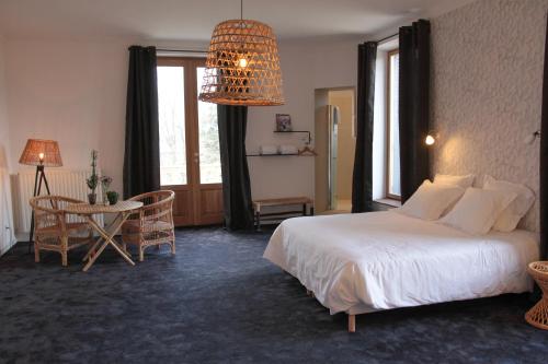 a hotel room with a bed and a table and a room at Eclosion Château Hôtel & Restaurant in Saint-Paul-en-Jarez
