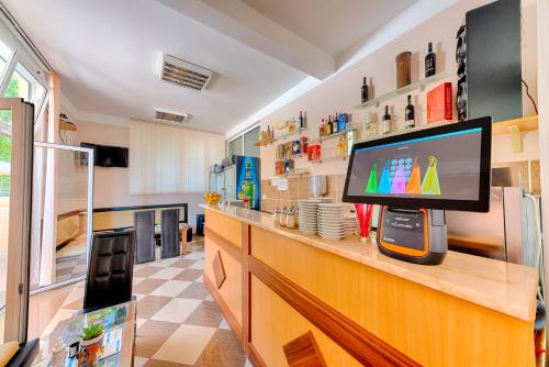 a kitchen with a flat screen tv on a counter at HOTEL DANA in Čanj