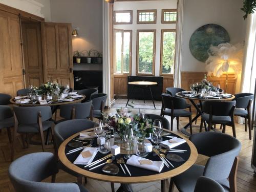 a dining room with two tables and chairs at Eclosion Château Hôtel & Restaurant in Saint-Paul-en-Jarez