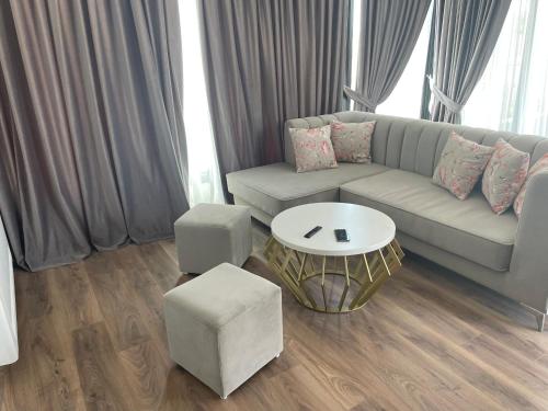 a living room with a couch and a table at Perla Luxury Penthouse in Tirana