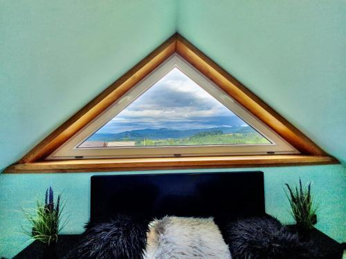 a hexagonal window in a room with a bed with at Rajska Chata w górach z Balią in Soblówka