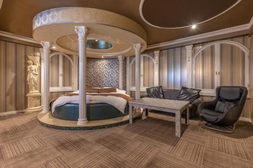 a bedroom with a bed and a table and chairs at ホテル ブランチャペルクリスマス 四日市 in Yokkaichi
