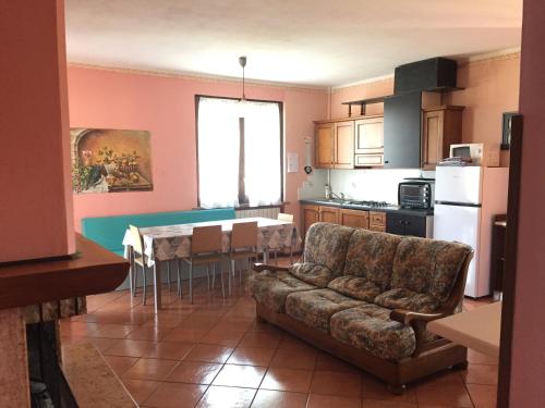 a living room with a couch and a kitchen at Le Tre Bandiere in Puegnago